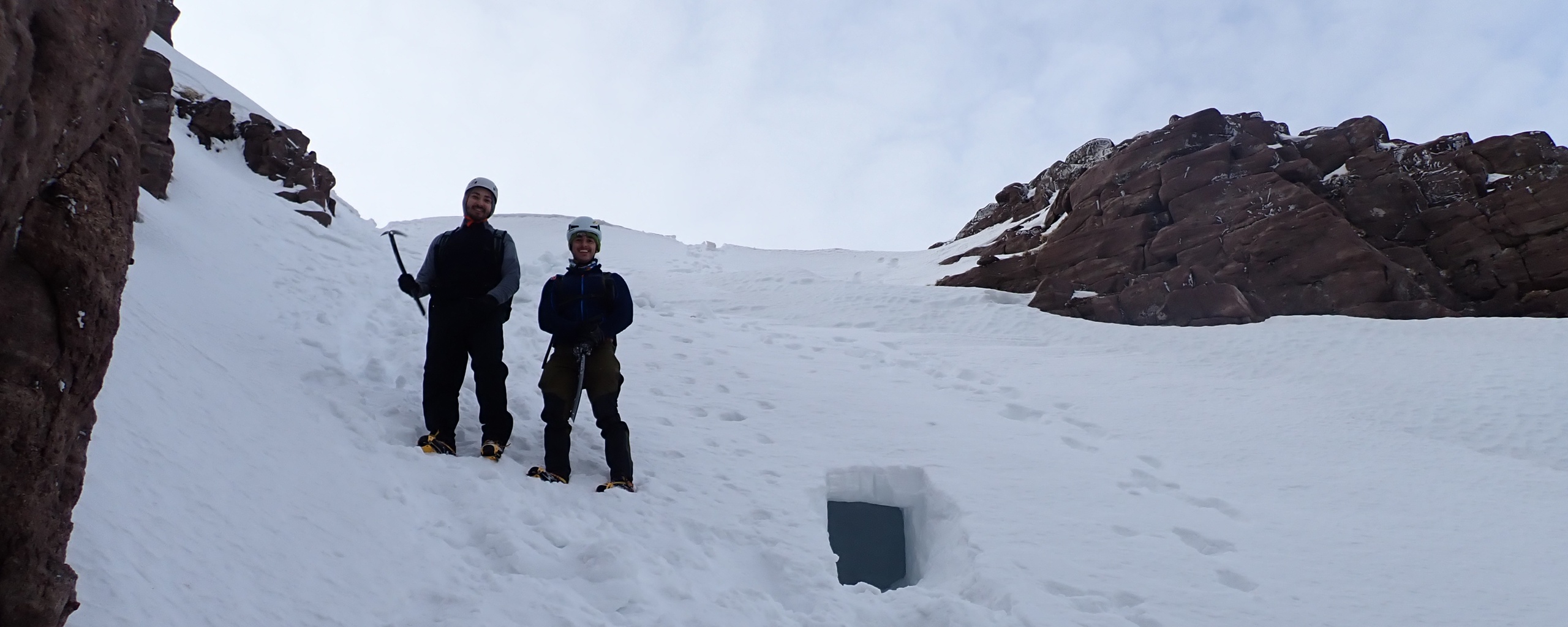 Two clients exploring a snow hole after a snowholing course.